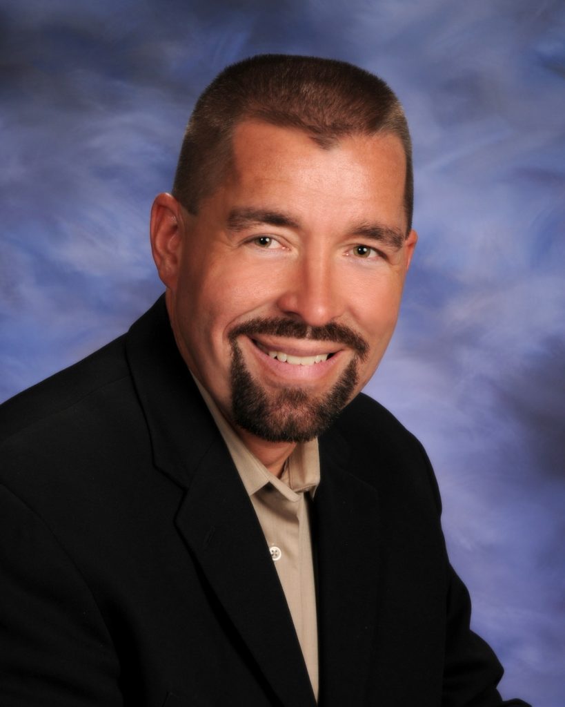 head shot of man with goatee smiling